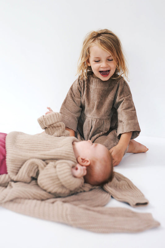 beige dress from corduroy with wooden buttons on the back- cloth took part in photo session